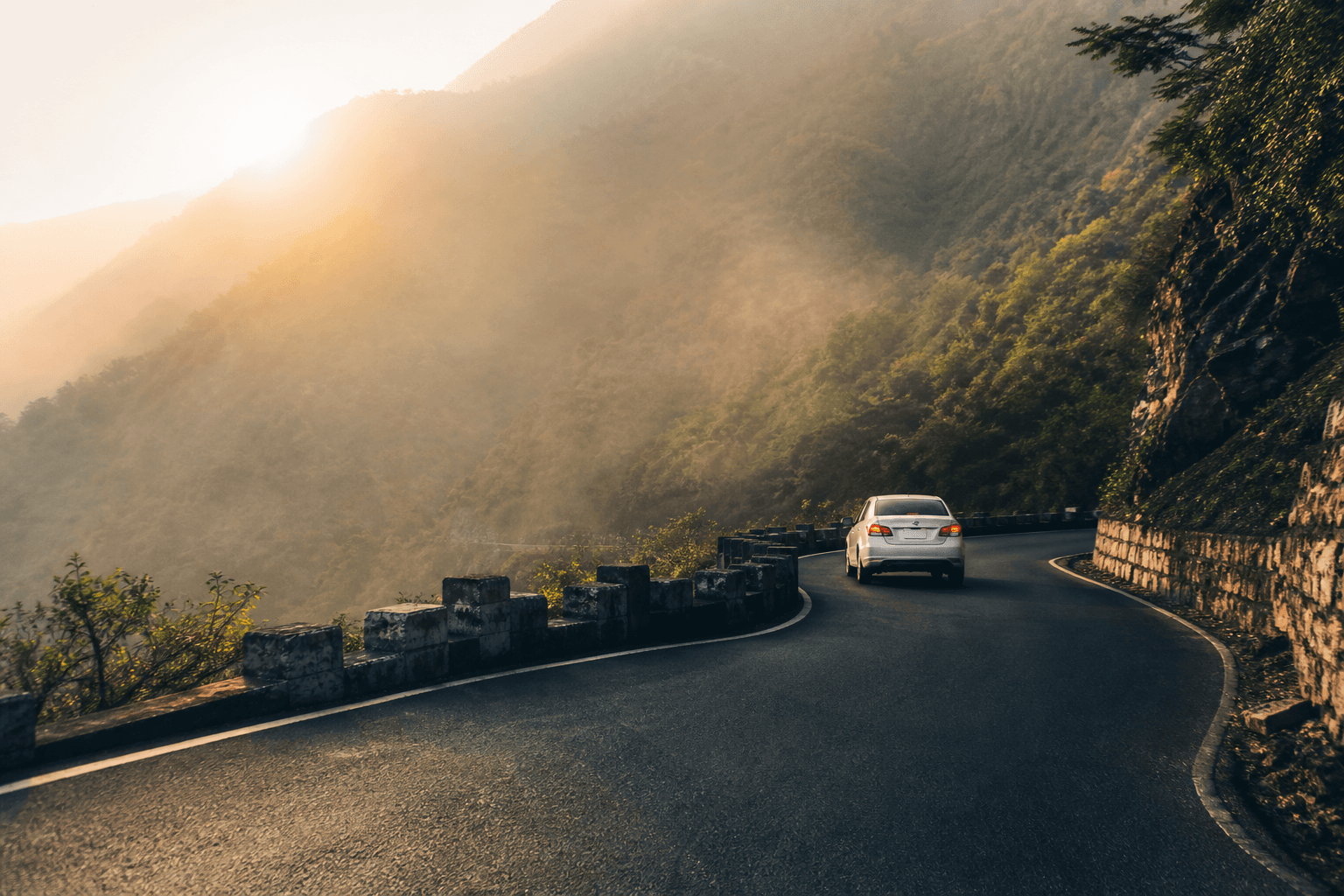 Scenic Rajgir hills road with a distant white Rathya taxi